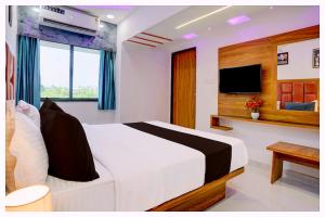 une chambre avec un lit blanc et une télévision dans l'établissement Hotel Swastik Dham Palace Near Near APJ Kalam Park - Luxury And Spacious Room - Fully Air Conditioned Rooms- Best Hotel Bhubneshwar, à Cuttack