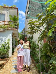a woman and a child standing next to a building at Tam Coc My Tho Homestay in Vũ Lâm