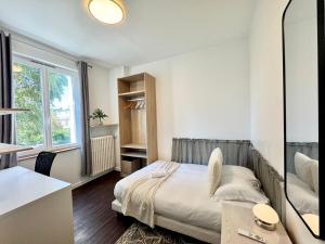 une petite chambre avec un lit et un miroir dans l'établissement La Maison d'Eugène, Rennes centre, à Rennes