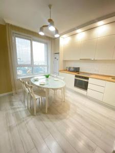 une cuisine avec une table blanche et des chaises dans l'établissement Only sun, à Astana
