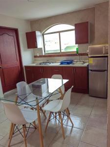 a kitchen with a glass table and white chairs at Entire apartment on Av Tollocan in Toluca