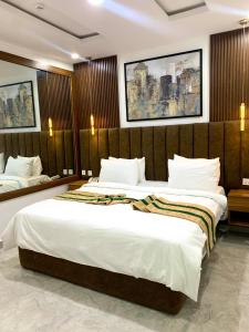 a hotel room with two beds with white sheets at De Emerald Hotel & Apartments in Atan
