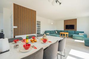 a living room with a table with chairs and a couch at Villa Panorama Maison de charme avec jardin in Oyonnax