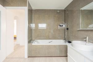 a bathroom with a white tub and a sink at Villa Panorama Maison de charme avec jardin in Oyonnax