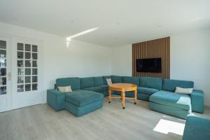 a living room with a blue couch and a table at Villa Panorama Maison de charme avec jardin in Oyonnax