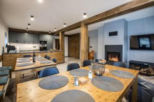 a dining room with tables and chairs and a fireplace at Chalet Lucie in Bedřichov