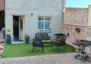 a patio with chairs and a table on grass at Le "Therdon'Oise" - Maison, gardiennage & navette in Therdonne