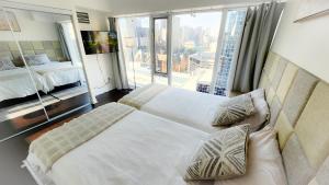 a hotel room with two beds and a large window at Pantages Skyline Suite in Toronto Centre - Free Parking in Toronto +14 photos