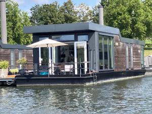 a house on a floating dock on the water at De Maasterp - Watervillage 16 in Ohé en Laak