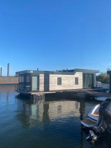 a house on a dock on a body of water at De Maasterp - woonboot 14 in Montfort