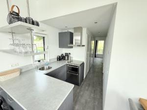 a kitchen with white walls and a counter top at De Maasterp - Woonboot 16 in Montfort