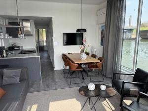 a living room and kitchen with a table and chairs at De Maasterp - woonboot 14 in Montfort +7 photos