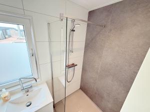 a bathroom with a shower and a sink at De Maasterp - Woonboot 16 in Montfort +8 photos