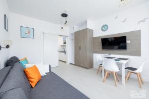 a living room with a couch and a table and chairs at Mewa Aquamarina Onyx D&D Apartments in Międzyzdroje +43 photos