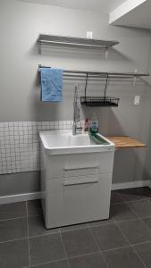 a kitchen with a sink and a tiled wall at Modern unit on Burke Mountain - FIFA 2026 in Port Coquitlam
