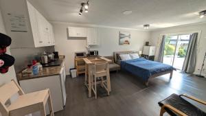 a kitchen and a living room with a bed and a table at Modern unit on Burke Mountain - FIFA 2026 in Port Coquitlam