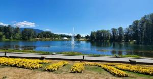 a park with a lake with a fountain and flowers at Modern unit on Burke Mountain - FIFA 2026 in Port Coquitlam