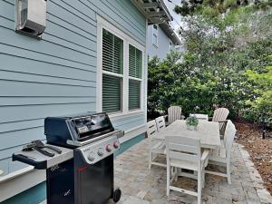 a patio with a grill and a table with chairs at Emerald Escape in Blue Gulf Beach