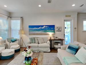 a living room with white couches and a table at Emerald Escape in Blue Gulf Beach