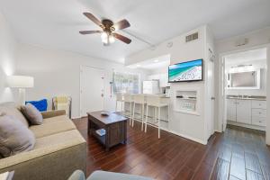 a living room with a couch and a ceiling fan at Sea Club II By Beachside Management in Siesta Key