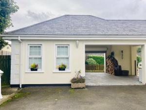 a white house with two windows and a garage at 1 Bed Flat - Sleeps 2 - Pets - Parking - Garden in Eglinton