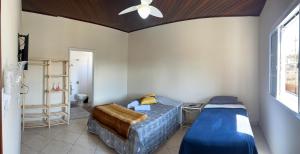 a bedroom with a bed and a ceiling fan at Pousada Jandi in São Miguel Arcanjo