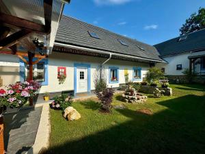a house with a yard with rocks and plants at Statek Březina in Březina