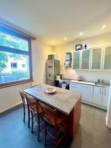 a kitchen with a table and chairs and a refrigerator at Appartement Cosy & Confort - Jardin in La Wantzenau