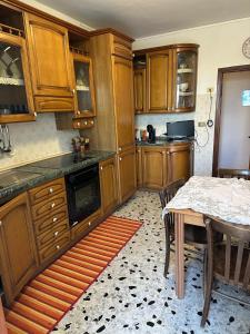 a kitchen with wooden cabinets and a table with chairs at Casa della zia rosa in Valentano