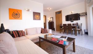 a living room with a couch and a table at Ascot By The Sea in St Paul's Bay