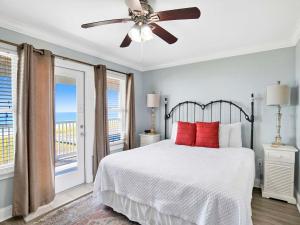 a bedroom with a bed with red pillows and a ceiling fan at Serenity Eden in Perdido Key
