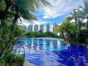 une grande piscine bordée de palmiers et de grands bâtiments dans l'établissement Forest City Near Marina Hotel - Kylin Apartment, à Gelang Patah