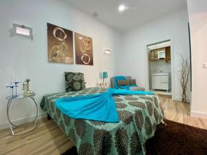 a bedroom with a bed with a blue blanket on it at Light Keys-Setubal DownTown&Beach in Setúbal