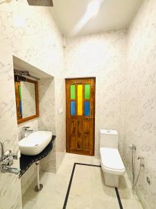 a bathroom with a sink and a toilet and a window at Hotel Muskan Heritage in Jaisalmer +31 photos