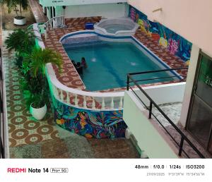 a swimming pool with a mural on the side of a building at Hotel donde Tito in Tolú
