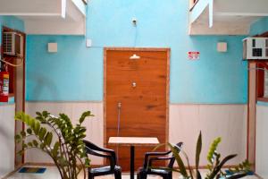 a room with a table and chairs and a wooden door at Pousada Solar da Praia in Guarapari