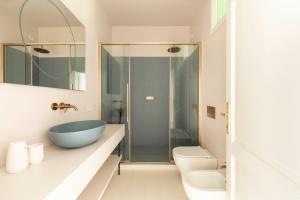 ein Badezimmer mit einem blauen Waschbecken und einer Dusche in der Unterkunft Ruga23 -1 in Cortona