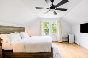 ein Schlafzimmer mit einem Bett und einem Deckenventilator in der Unterkunft Hamptons Cottage, Sleeps 7 in East Quogue
