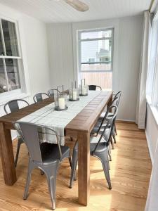 ein Esszimmer mit einem Holztisch und Stühlen in der Unterkunft Hamptons Cottage, Sleeps 7 in East Quogue + 10 Fotos