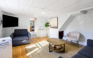 ein Wohnzimmer mit Sofa und Tisch in der Unterkunft Hamptons Cottage, Sleeps 7 in East Quogue