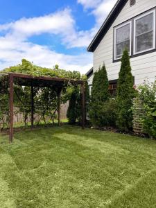 eine Pergola in einem Hof neben einem Haus in der Unterkunft Hamptons Cottage, Sleeps 7 in East Quogue