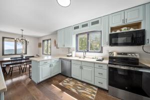 a kitchen with white cabinets and a black appliances at Mountain Sunrise in Blowing Rock