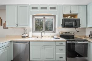 a kitchen with white cabinets and a sink and a window at Mountain Sunrise in Blowing Rock +25 photos
