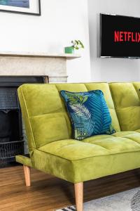 un sofá verde en una sala de estar con chimenea en Brighton 2 Bed Brunswick, en Brighton & Hove