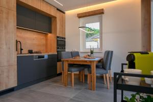 a kitchen with a wooden table and chairs at L'ari-Fáry Home in Sárvár
