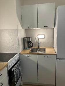 een kleine keuken met witte kasten en een spoelbak bij Yksiö Asemakadulla in Lapua