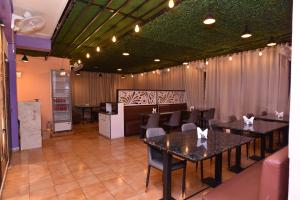 a dining room with tables and chairs and a kitchen at Hotel Hill View in Guwahati