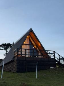 a large wooden house with a pitched roof at Chalé A-Frame da Fazenda in Bom Jardim da Serra