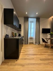 a kitchen with a counter and a table in a room at Urban Chic Apartment Black in Como