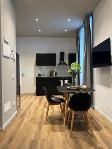 a kitchen and dining room with a table and chairs at Urban Chic Apartment Black in Como +5 photos